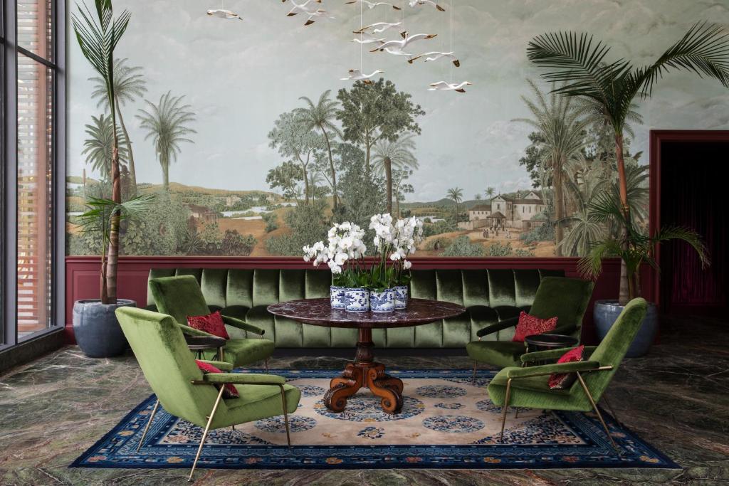 ein Wohnzimmer mit einem Tisch und grünen Stühlen in der Unterkunft Hotel Montevideo - Leading Hotels of the World in Montevideo