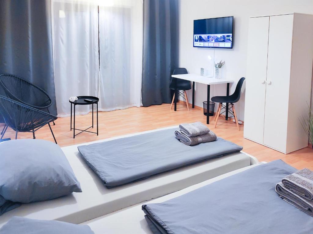 1 dormitorio con 2 camas, mesa y sillas en ALFA Apartment Stuttgart Mitte 2 Zimmer City-Lage Berliner Platz Balkon Netflix Küche WM, en Stuttgart