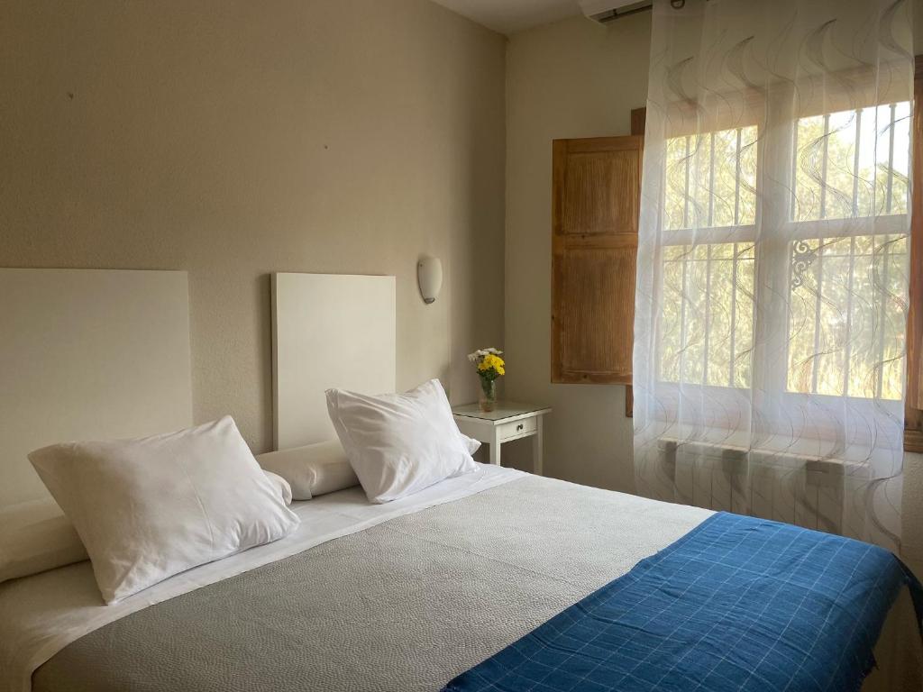 A bed or beds in a room at Hostal Moscatel