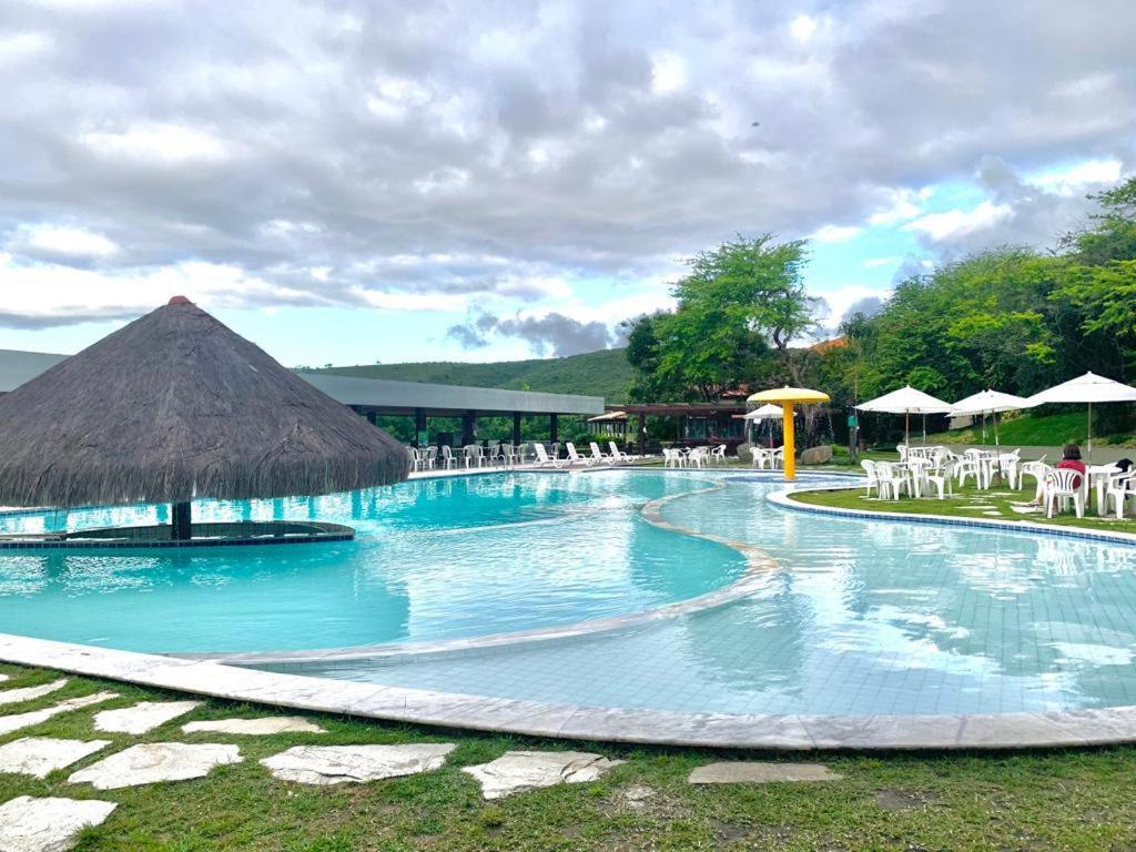 ein großer Swimmingpool mit Liegen und Sonnenschirmen in der Unterkunft Gravatá Flat no condomínio Monte Castelo MELHOR LOCALIZAÇÃO , Wi-Fi, SKY e AR in Gravatá