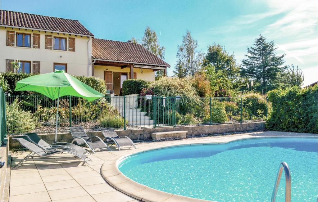 - une piscine avec 2 chaises et un parasol dans l'établissement 3 Bedroom Beautiful Home In St, Saud Lacoussiere, à Saint-Saud-Lacoussière