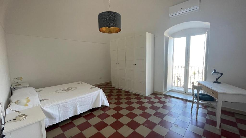 sypialnia z łóżkiem, biurkiem i oknem w obiekcie Casa Vacanze Zingari w mieście Minervino Murge