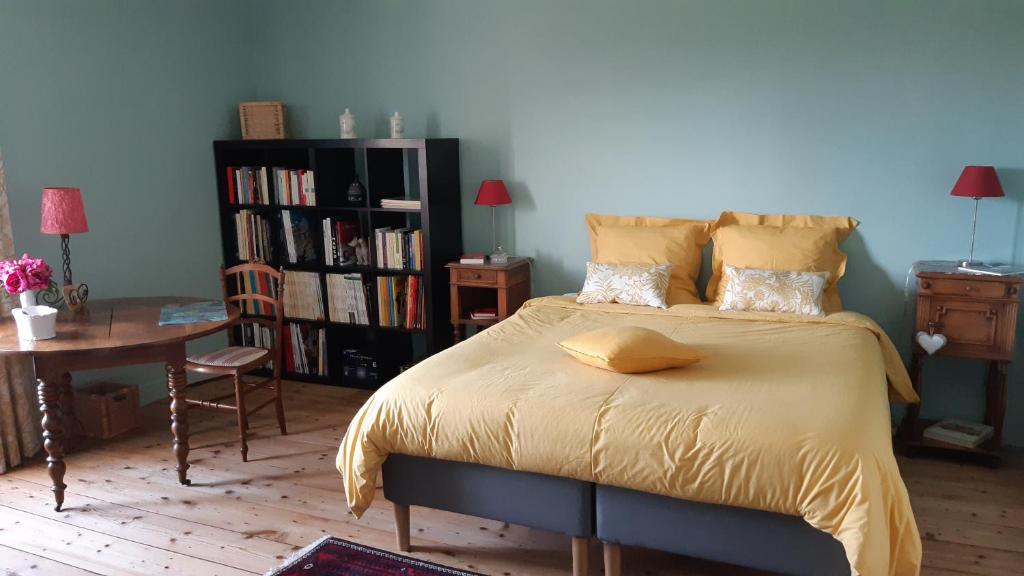 a bedroom with a bed with a yellow blanket on it at Chambres d'Hôtes Les Jardins de la Cathédrale in Angoulême