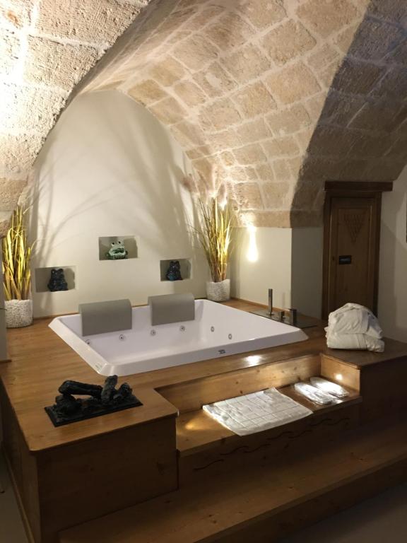 una vasca da bagno in una camera con parete in pietra di La Maison de Nicole Monopoli a Monopoli