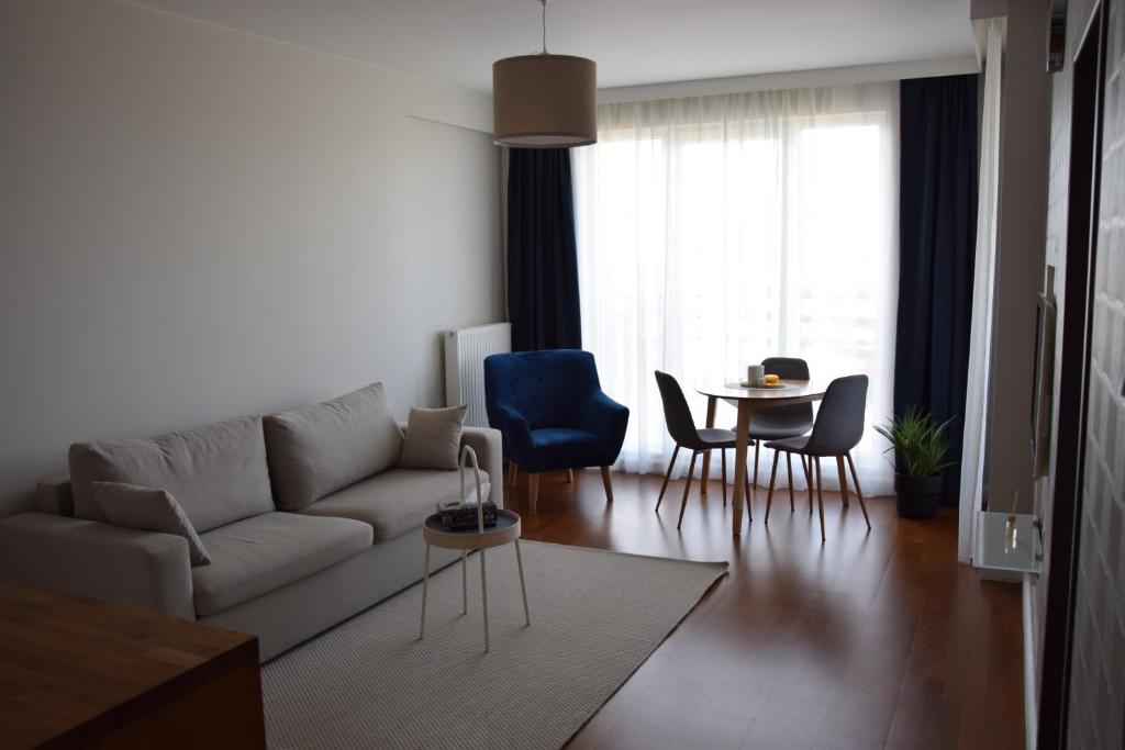 a living room with a couch and chairs and a table at Warsaw City Break in Pruszków