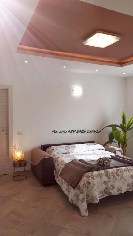 ein Schlafzimmer mit einem Bett mit einem Schild an der Wand in der Unterkunft LONATE SUITE in Lonate Ceppino