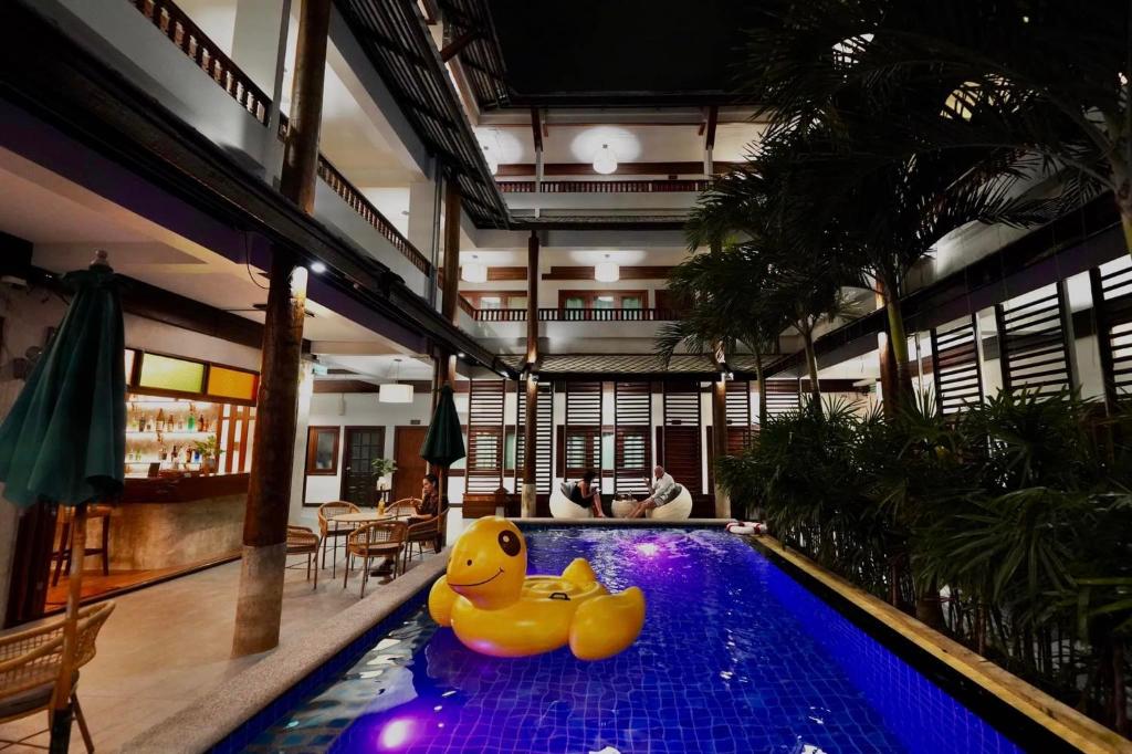 A narrow illuminated courtyard pool beneath a multi-storey hotel atrium.