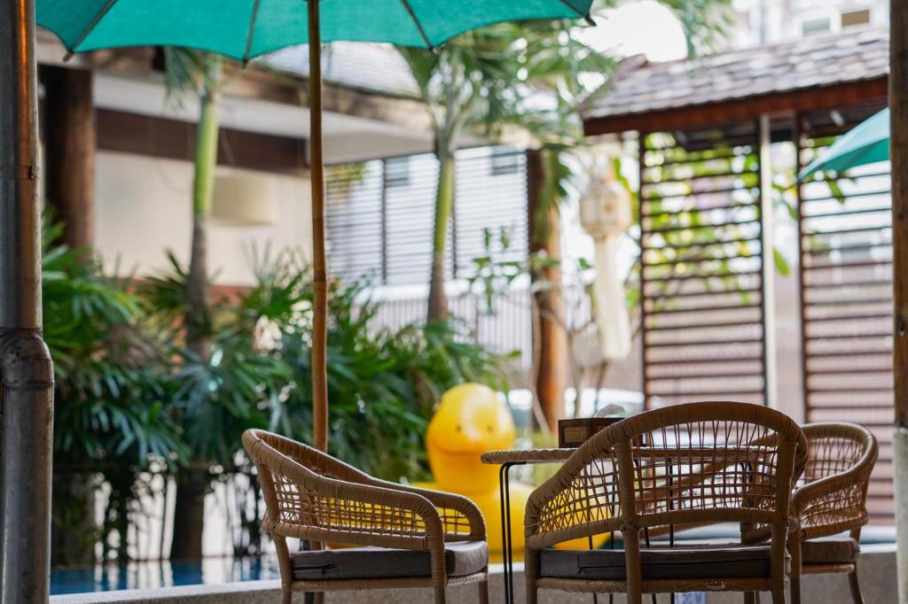 A shaded courtyard seating nook beside the pool and tropical planting.