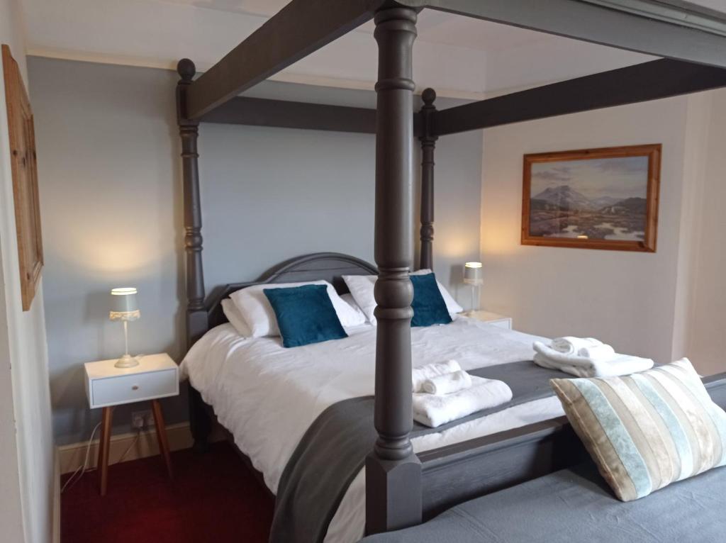 a bedroom with a four poster bed with blue pillows at Castle Inn in Hythe