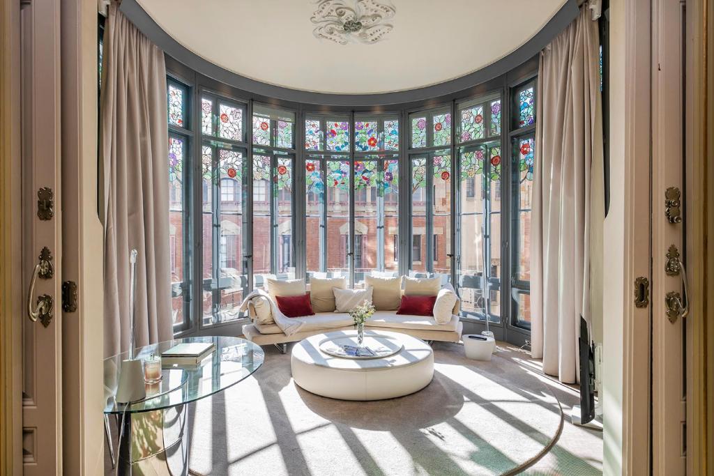 a living room with a couch and a large window at El Palauet Royal Suites in Barcelona