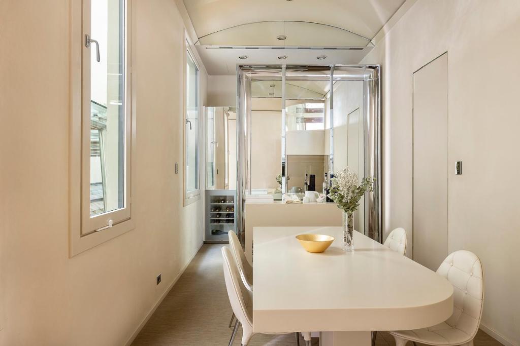 a white dining room with a white table and chairs at El Palauet Royal Suites in Barcelona