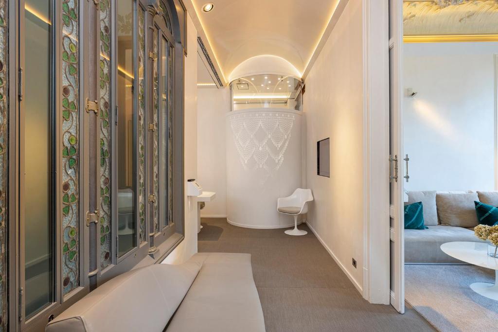a room with a hallway with a couch and a table at El Palauet Royal Suites in Barcelona