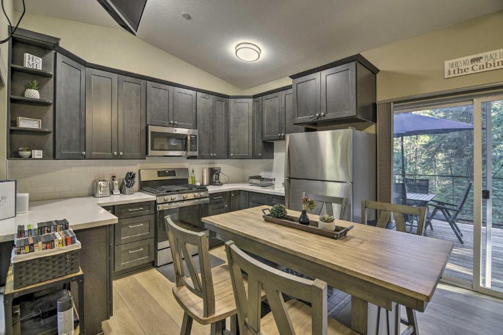 a kitchen with wooden cabinets and a wooden table at Secluded Butte Meadows Cabin with Deck and Grill! 