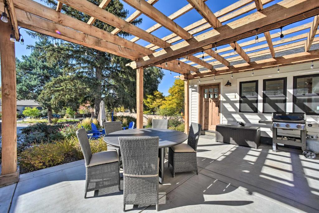 eine Terrasse mit einem Tisch und Stühlen unter einer hölzernen Pergola in der Unterkunft Castle Rock Cottage - Walk to Town! in Castle Rock