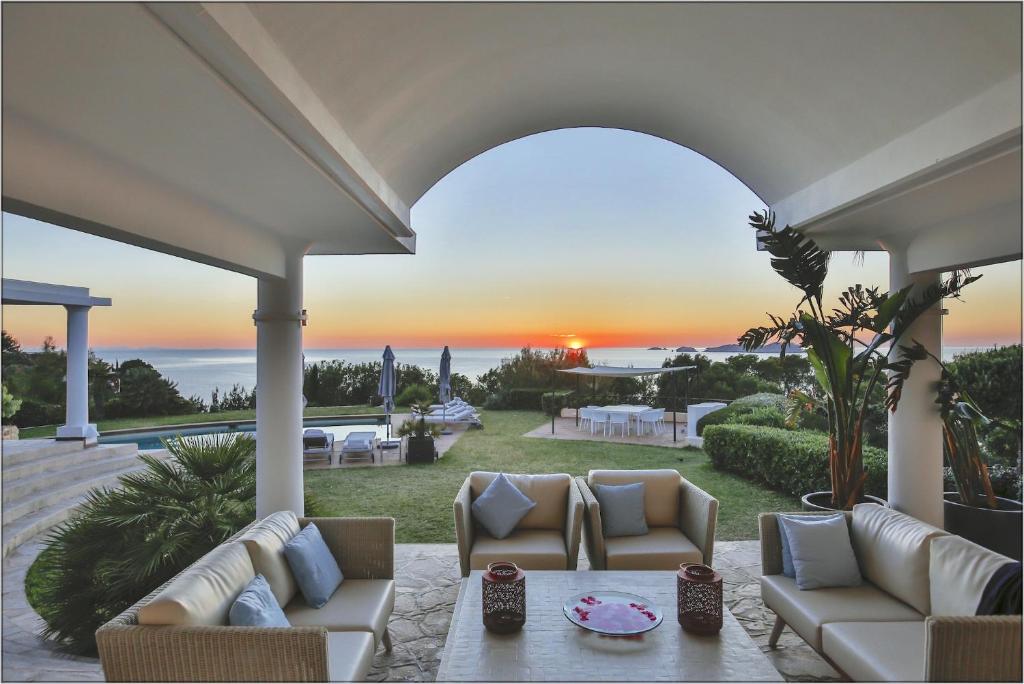 a patio with couches and a view of the ocean at Amazing Ibiza Villa Can Icarus 6 Bedrooms Perched On a Cliff Overlooking the Beach of Cala Moli San Jose in Sant Josep de sa Talaia