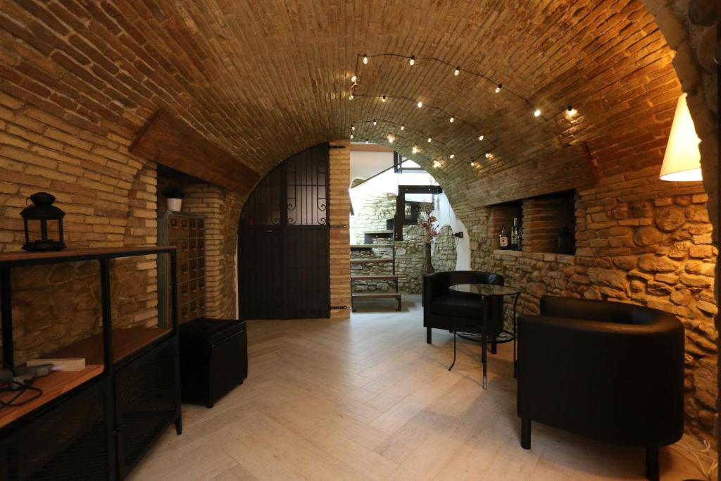 Habitación con pared de ladrillo, mesa y sillas. en PETITE MAISON, en Lanciano