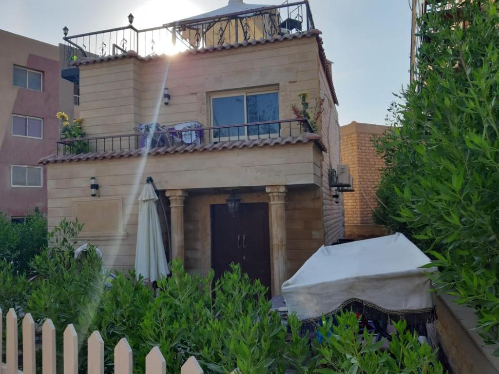 dom z balkonem i parasolem w obiekcie Villa in Venecia Village - Ain Sokhna w mieście Ajn Suchna