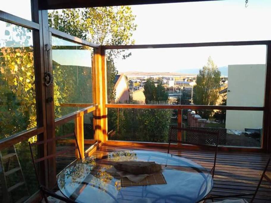 una mesa de cristal en un balcón con vistas en Mi lugar en el mundo en El Calafate