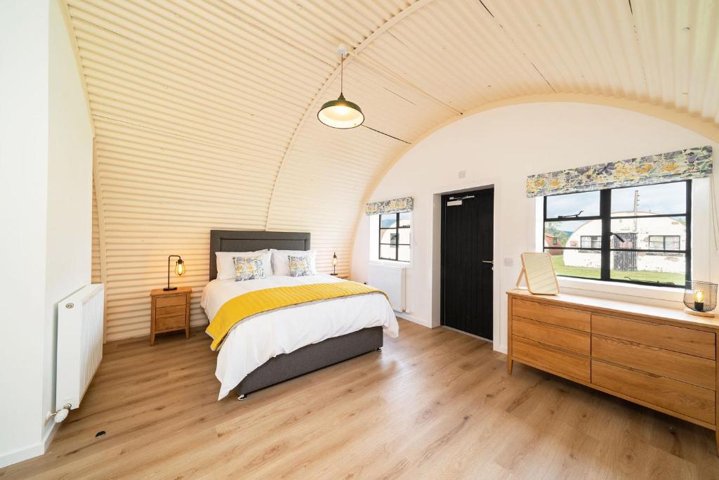 1 dormitorio con 1 cama, vestidor y ventana en Cultybraggan Hut 36, en Mill of Fortune