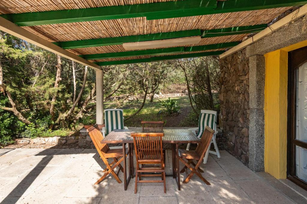Une table et des chaises en bois sont disponibles sur la terrasse. dans l'établissement Domus de Janas, à SantʼAntìoco