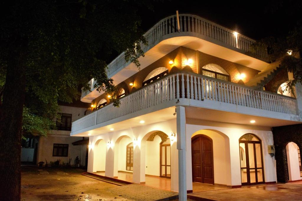 a large white building with a staircase on top at night at Murphy's Villa in Katunayaka