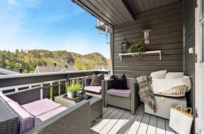 Un balcón con sillas moradas y una cama. en Sjarmerende familievennlig hus med 2 soverom en Kristiansand