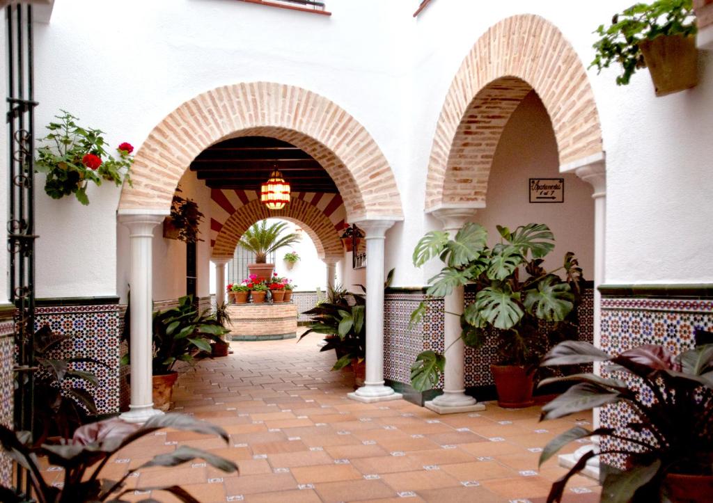 un pasillo de un edificio con arcos y macetas en Apartamentos Turísticos Los Patios, en Rota