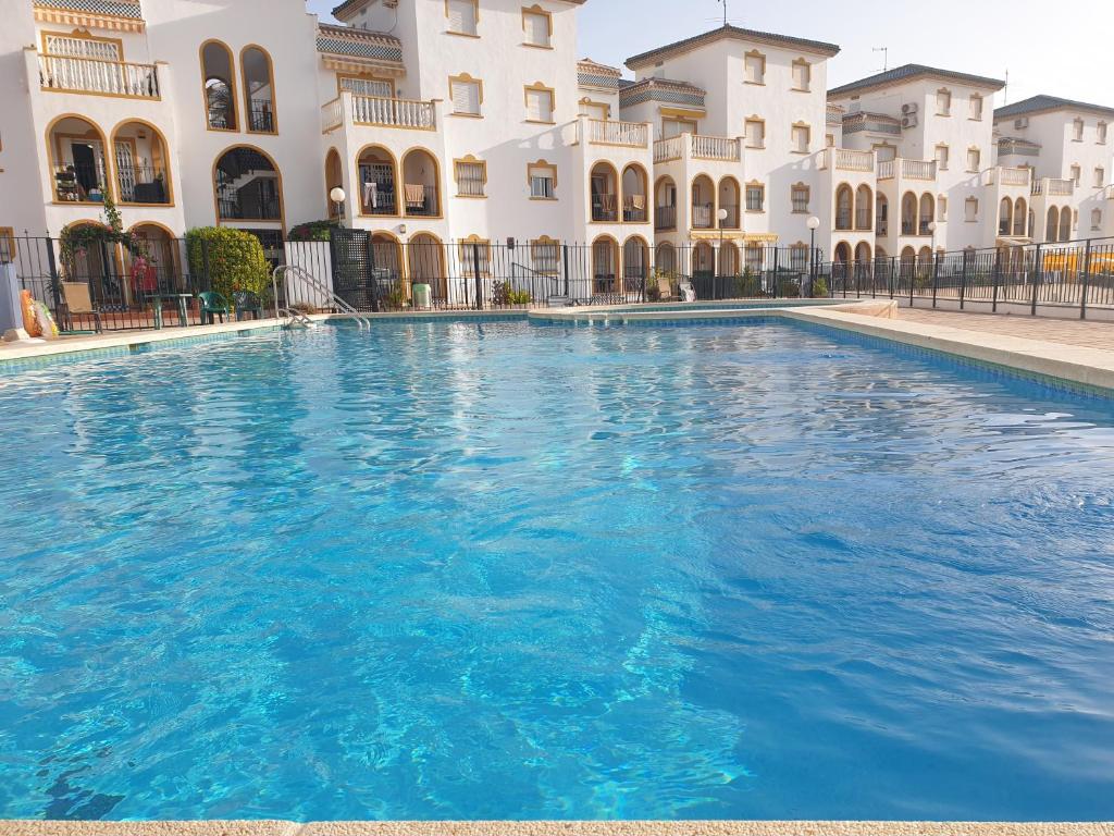 uma grande piscina em frente a um edifício em Sunlight Apartment - Molino Blanco - La Zenia em Playas de Orihuela
