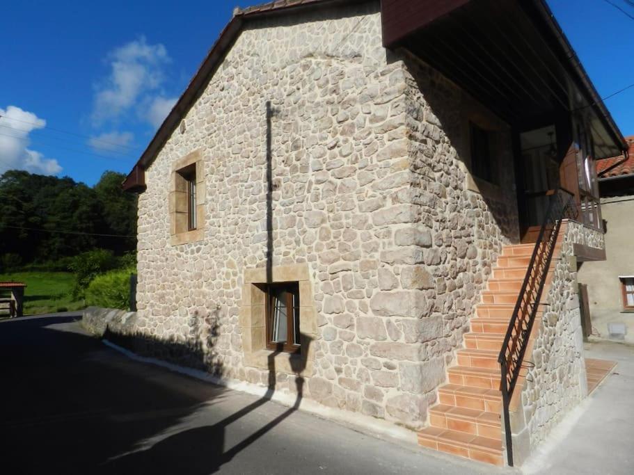 - un bâtiment en pierre avec des escaliers sur son côté dans l'établissement Apartamento en Treceño, Cantabria, à Treceño