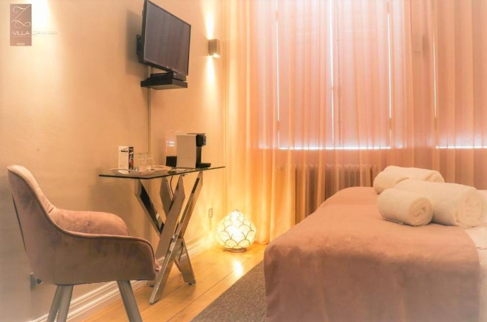 a bedroom with a bed and a table and a chair at Villa Zawaia B&B in Lagos