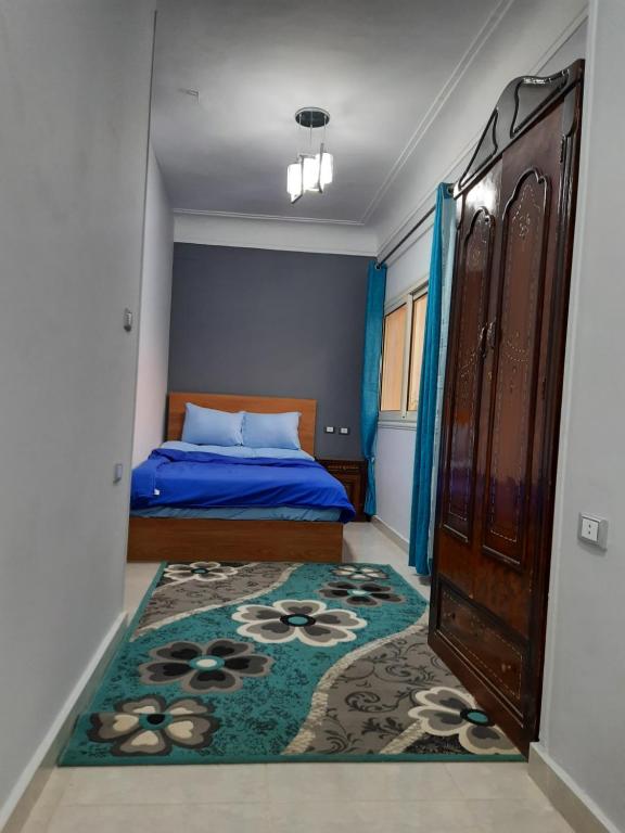 - une chambre avec un lit et un tapis dans l'établissement Aton pyramids view guest house, au Caire