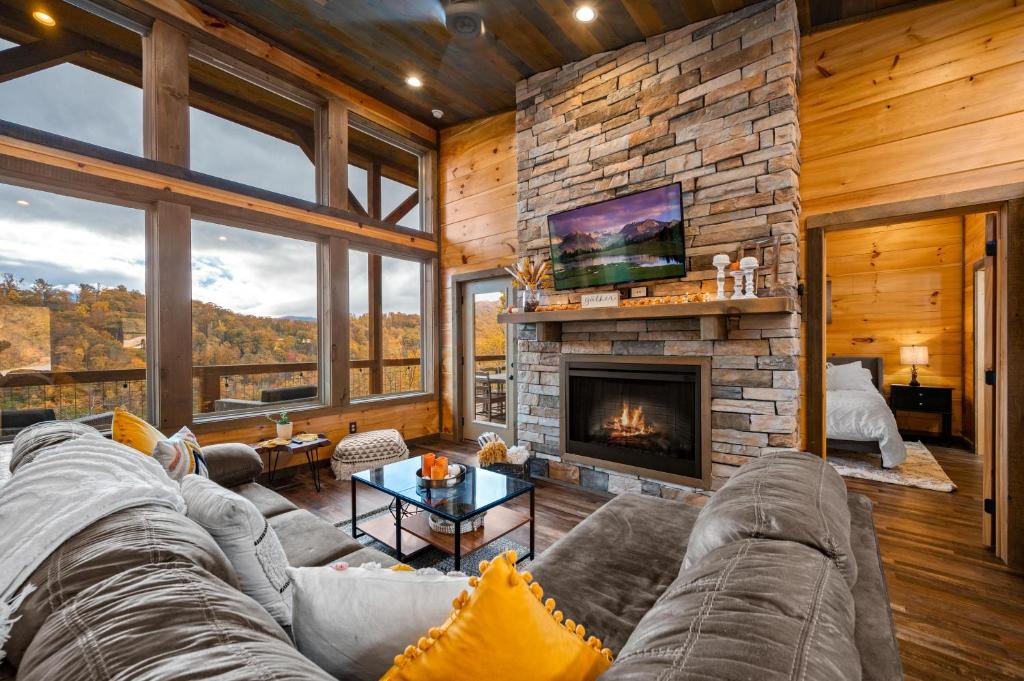 a living room with a couch and a fireplace at The Overlook - '21 Cabin - Gorgeous Unobstructed Views - Fire Pit Table - GameRm - HotTub - Xbox - Lots of Bears in Gatlinburg