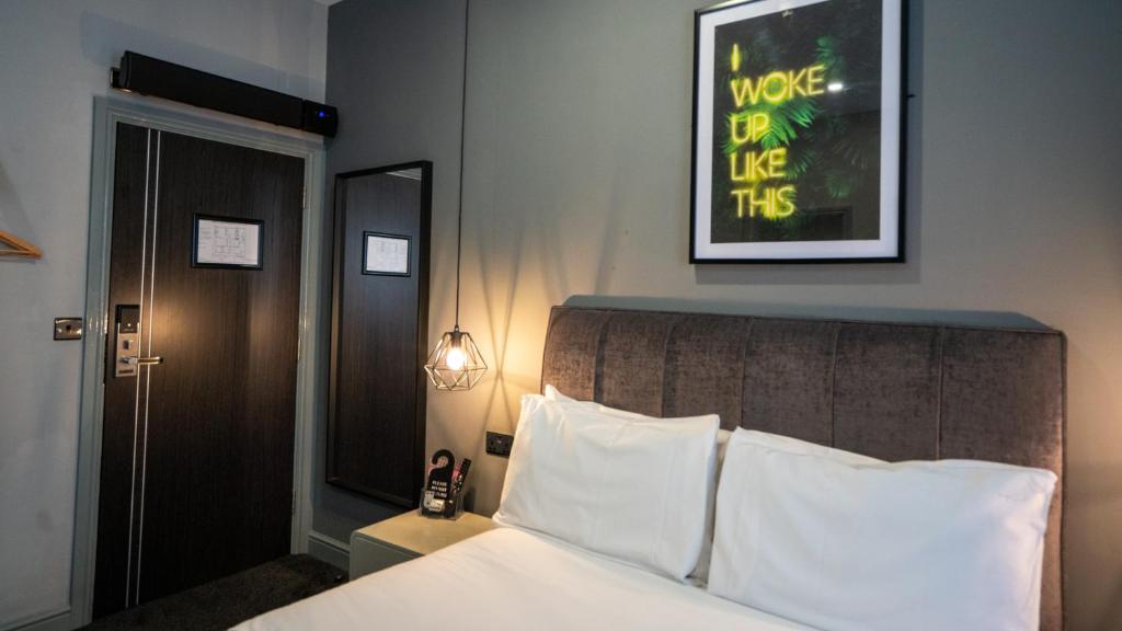 a bedroom with a bed and a picture on the wall at Hotel 105 in Liverpool