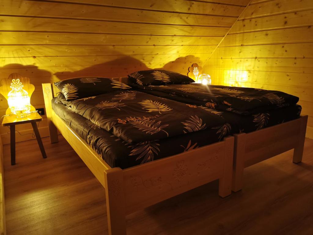 a bed in a wooden room with two lamps on it at Predlówka - Na dachu Świata in Zawoja