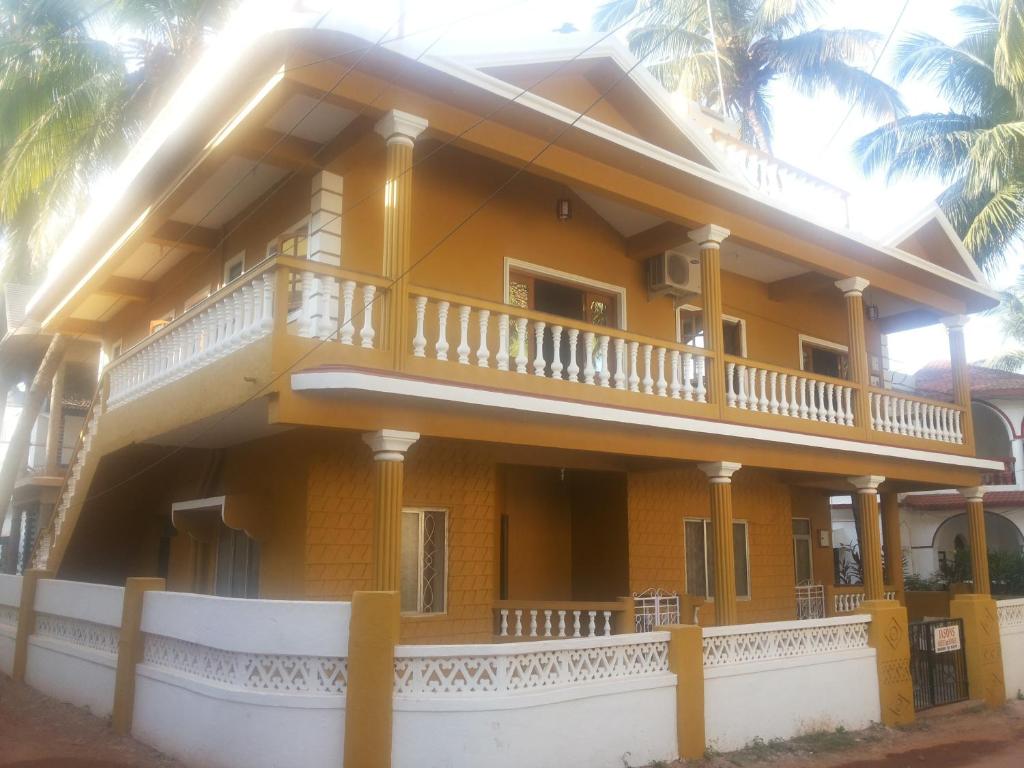 カンドリムにあるJason Guest Houseのバルコニー付きの大きな黄色の家