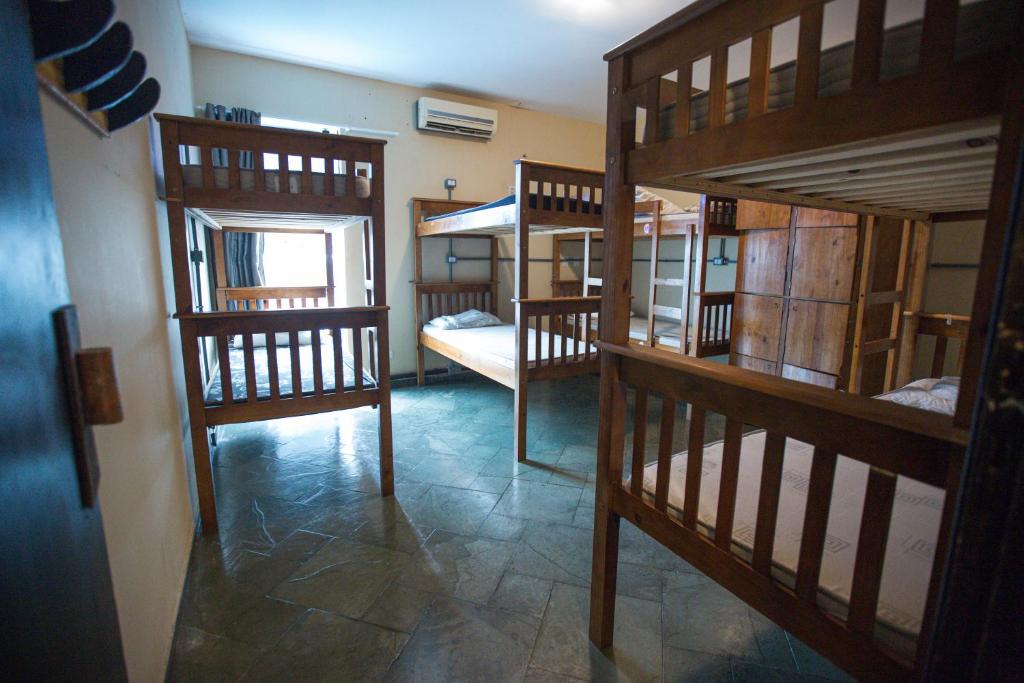 a room with several bunk beds in a room at Curvão Surf House in Guarujá