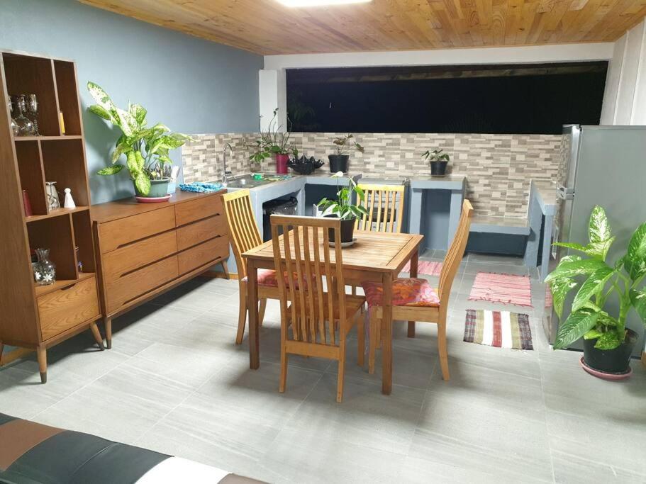 uma sala de jantar com mesa e cadeiras e uma cozinha em Ohana Location Ravissant appart spacieux parking gratuit à uturoa em Uturoa