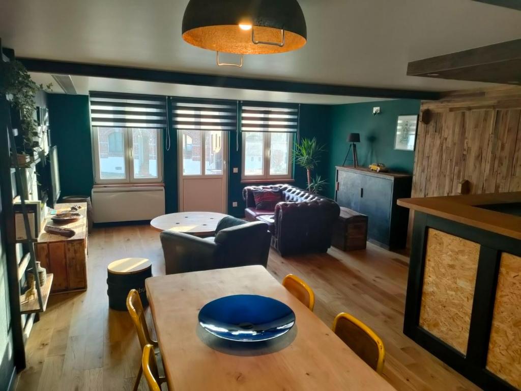 een woonkamer met een tafel en een bank bij L'Atelier in Saint-Laurent-Blangy