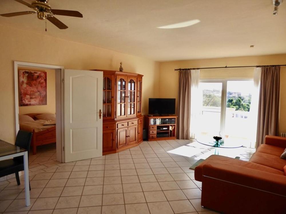 een woonkamer met een bank en een tv bij Dein Appartement Sunset View und Meer in La Pared