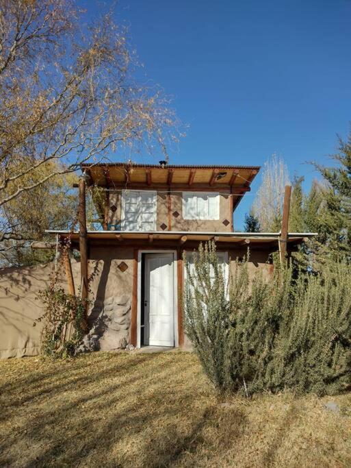 a small house with a window in a field at Hospedaje de Barro in La Consulta