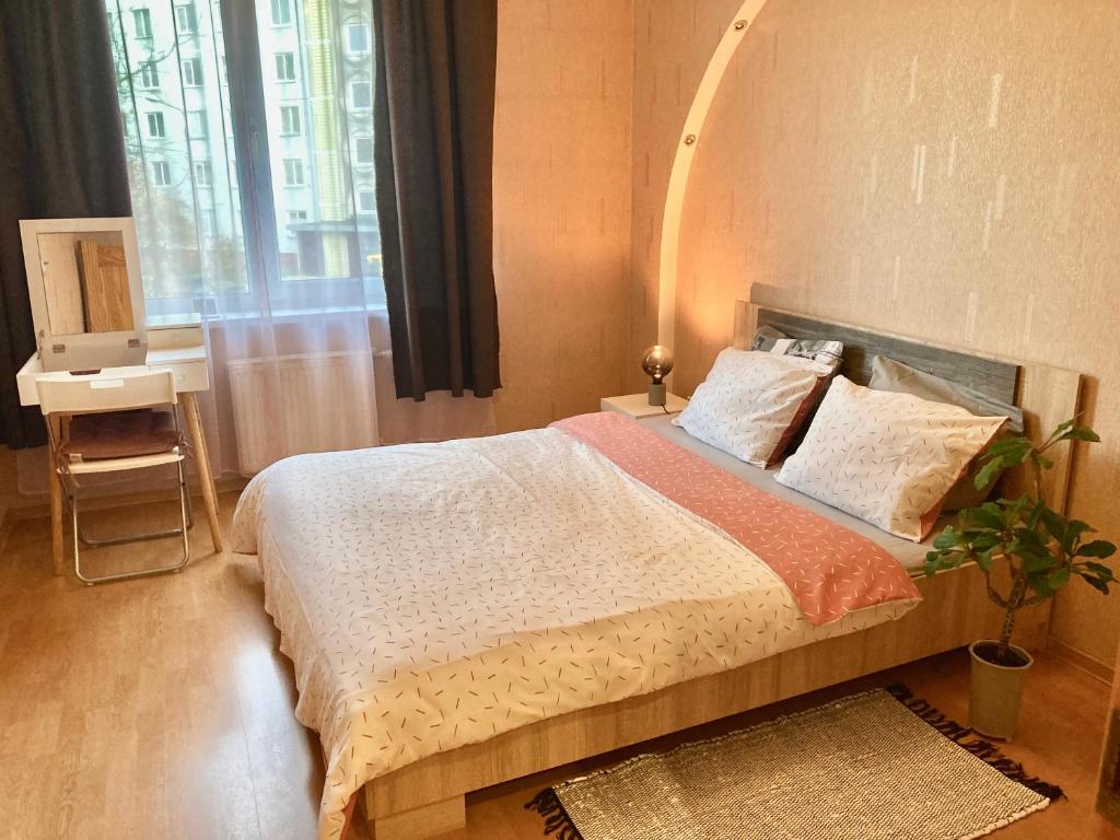 a bedroom with a large bed and a window at Apartment Saharova in Rīga