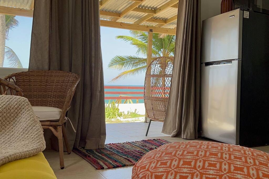 a living room with a refrigerator and a view of the beach at Casita Del Mar Oceanfront Romantic Retreat In Islote in Arecibo