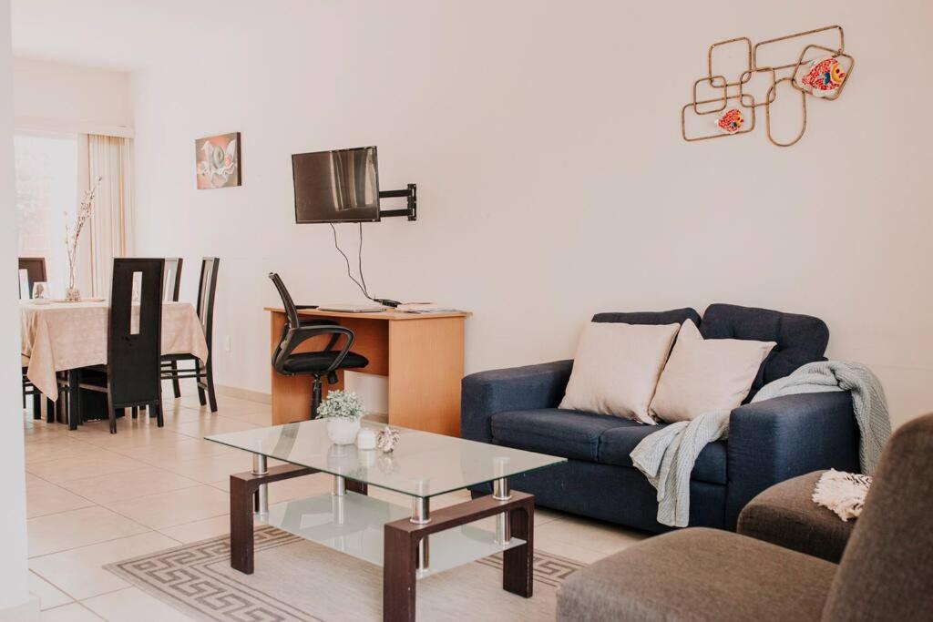 a living room with a blue couch and a table at Hermosa Moderna Casa en Privada in Aguascalientes