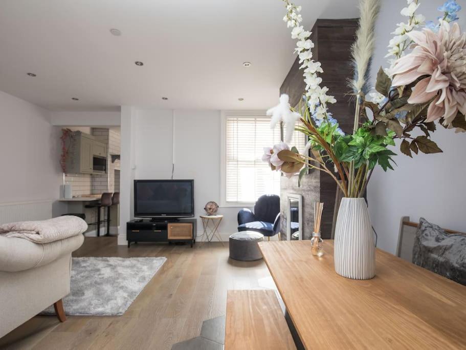 una sala de estar con un jarrón de flores sobre una mesa en Lovely 2-bedroom maisonette in Windsor, en Windsor