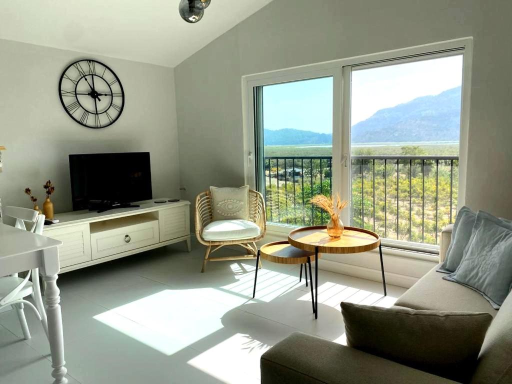 a living room with a tv and a large window at Airport Blue Eye Apartment Dalaman best Location also suitable for day rentals ideal for air travelers, 5 km close to airport in Dalaman