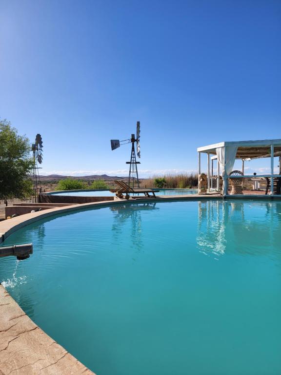 una gran piscina con un molino de viento en el fondo en Watervalsrivier Farm, en Prince Albert