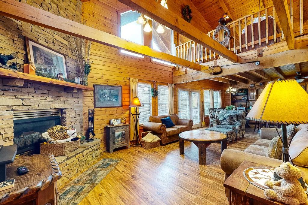 a living room with a stone fireplace in a log cabin at Fox Hollow in Little Cove