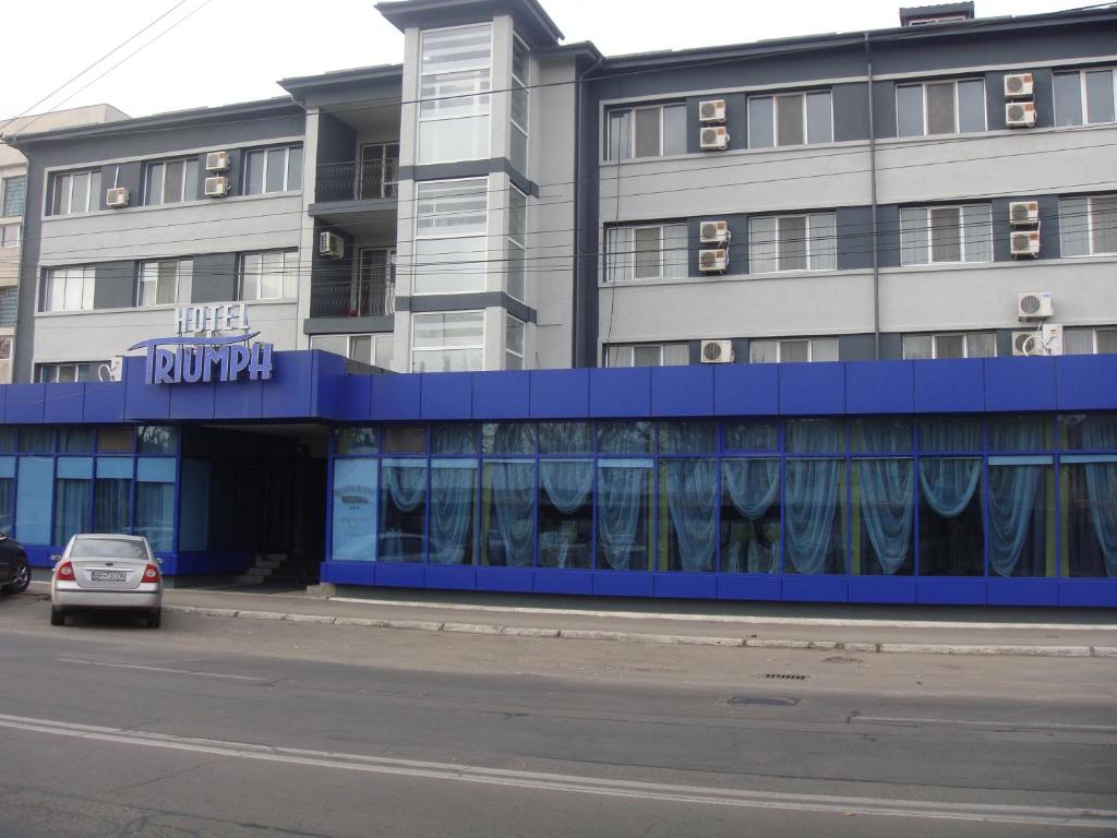 a building with a car parked in front of it at Hotel Triumph in Brăila