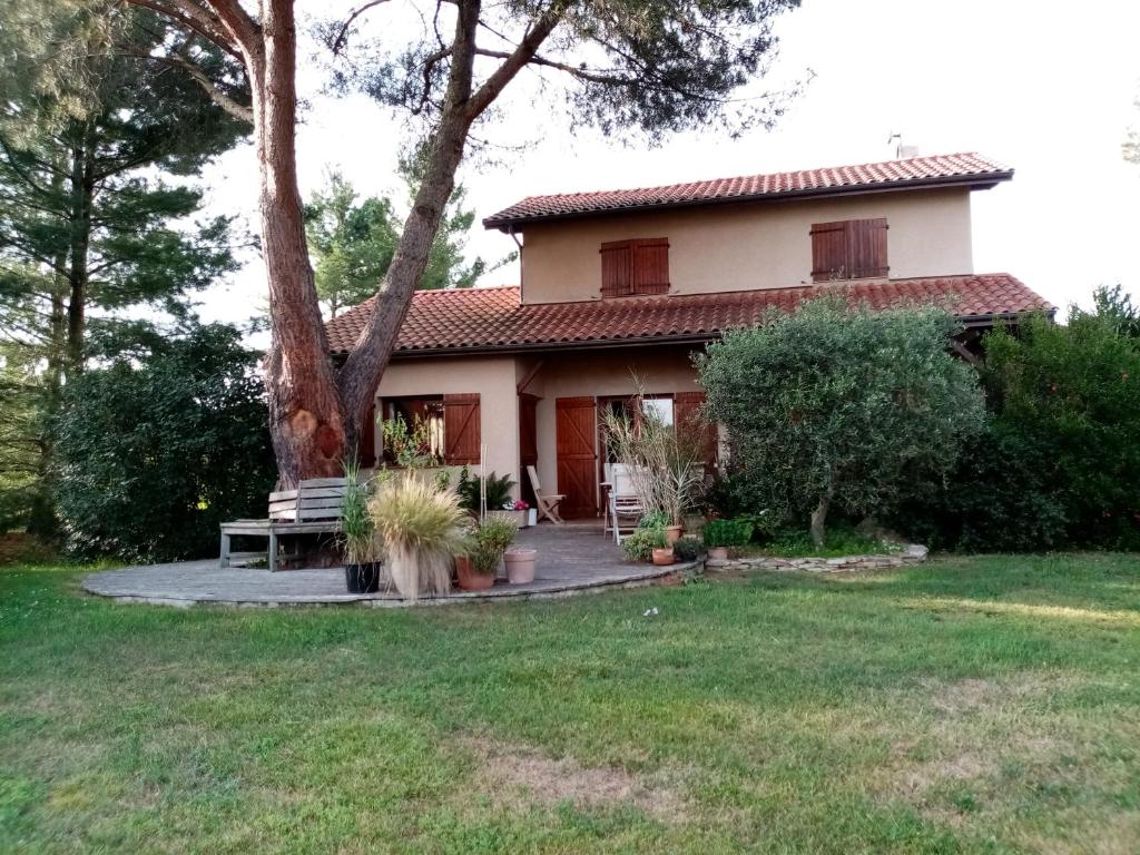 une maison avec un arbre dans la cour dans l'établissement Maison à la campagne, à Duffort