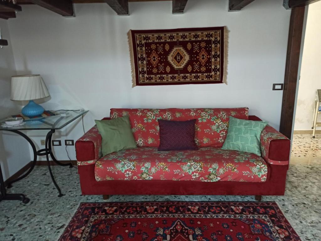ein rotes Sofa im Wohnzimmer mit einem Tisch in der Unterkunft Civico94 appartamenti in Paceco